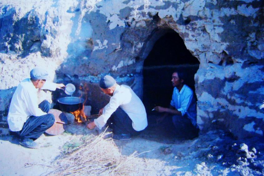 1983年，“六老漢”一代治沙人在“地窩子”生活做飯。新華社發(fā)（八步沙林場供圖）