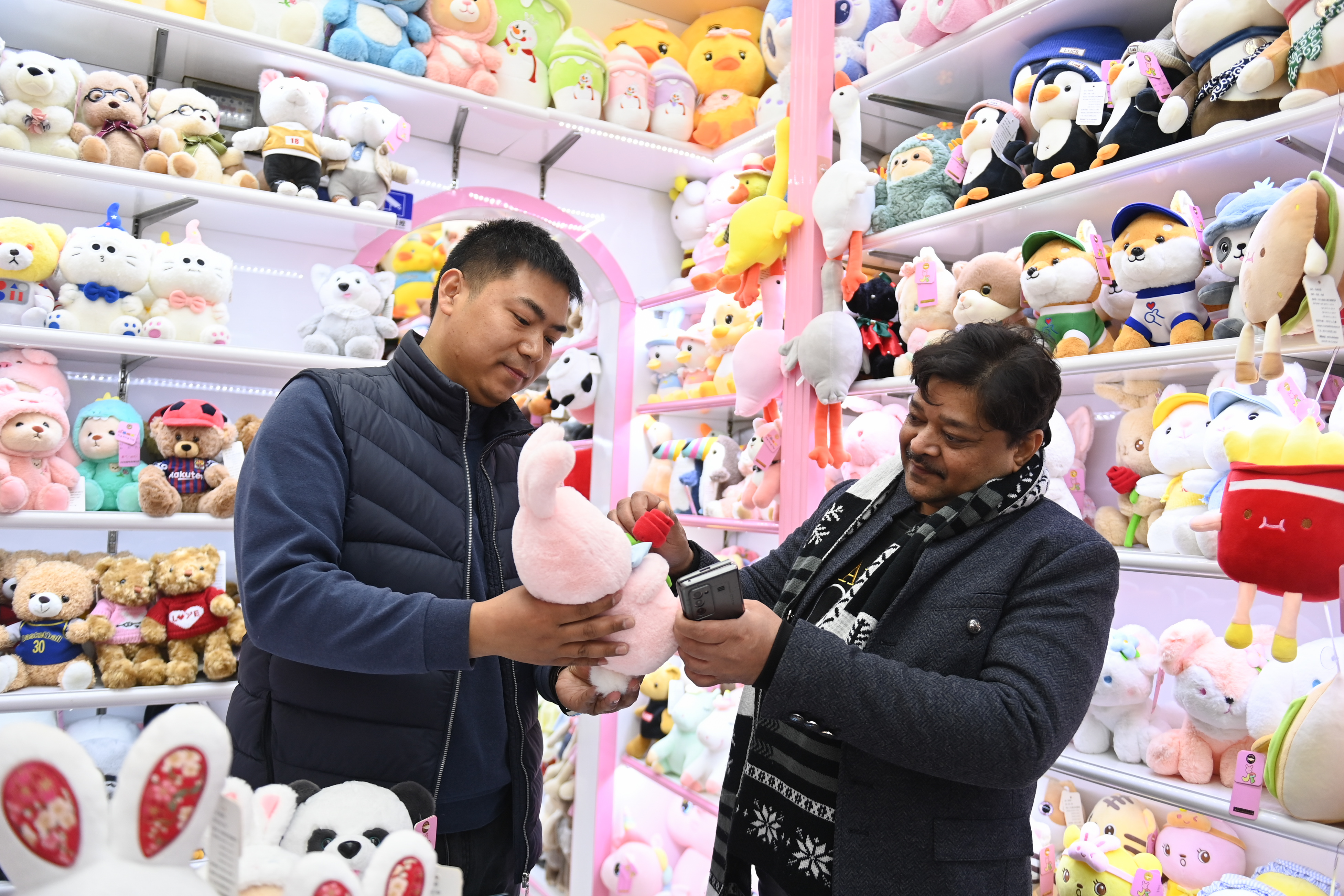 2023年2月2日，來(lái)自印度的客商（右）在義烏國(guó)際商貿(mào)城的一家玩具店鋪內(nèi)選購(gòu)。